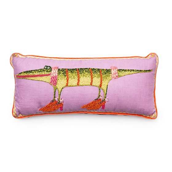 a pink pillow with an image of a dinosaur on it's back and legs