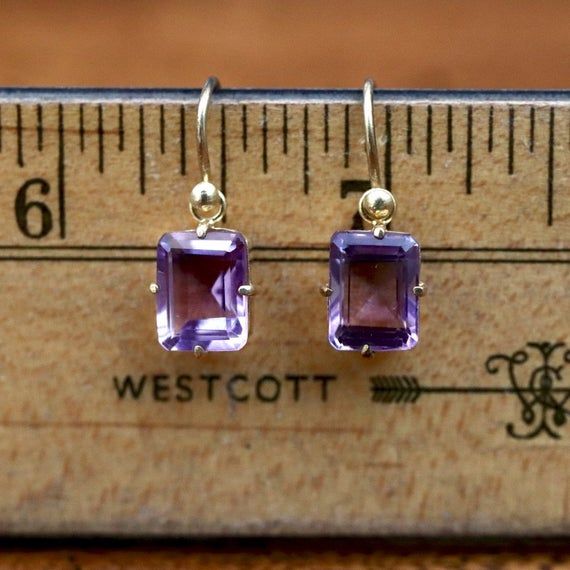 The faceted emerald cut dates back to the Renaissance. Art Deco jewelry sees a resurgence in this simple faceted rectangle.Gold vermeil setting featuring brilliant purple amethyst showcased by a simple french hoop and granule setting.  Height 3/4 inches including the earwire. Rectangular Prong Setting Earrings, Yellow Gold Faceted Jewelry With Rectangular Stone, Classic Emerald Cut Birthstone Gemstones, Yellow Gold Jewelry With Faceted Rectangular Stone, Fine Jewelry With Faceted Rectangular Stone, Square Diamond-cut Jewelry For Formal Occasions, Formal Rectangular Fine Jewelry Gemstones, Classic Rectangular Jewelry For Everyday, Formal Square Diamond Cut Jewelry