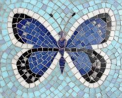 a blue and black butterfly is shown on a mosaic tile wall