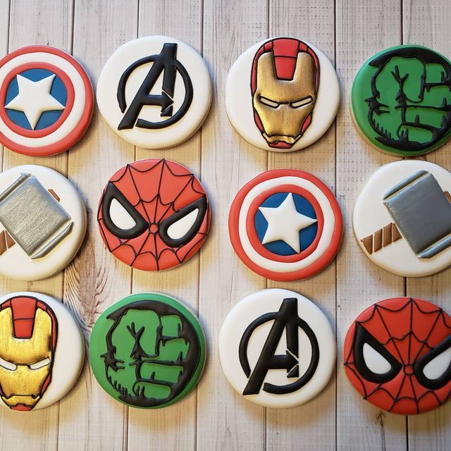 decorated cookies are arranged in the shape of superheros