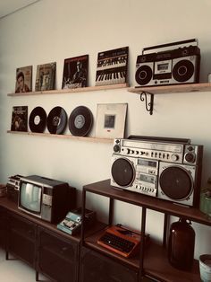 there are many old radio and stereos on the shelves in this living room,