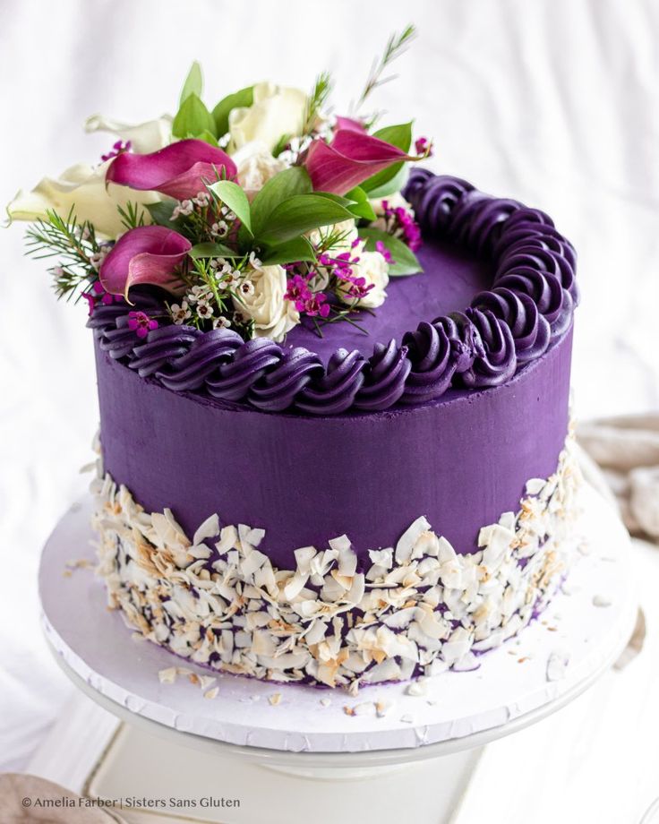 a cake with purple frosting and flowers on top