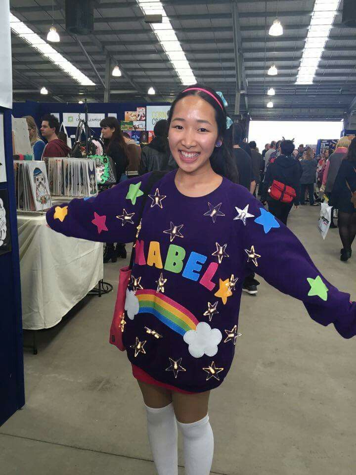 a woman in a purple sweater and white socks is standing with her arms spread out