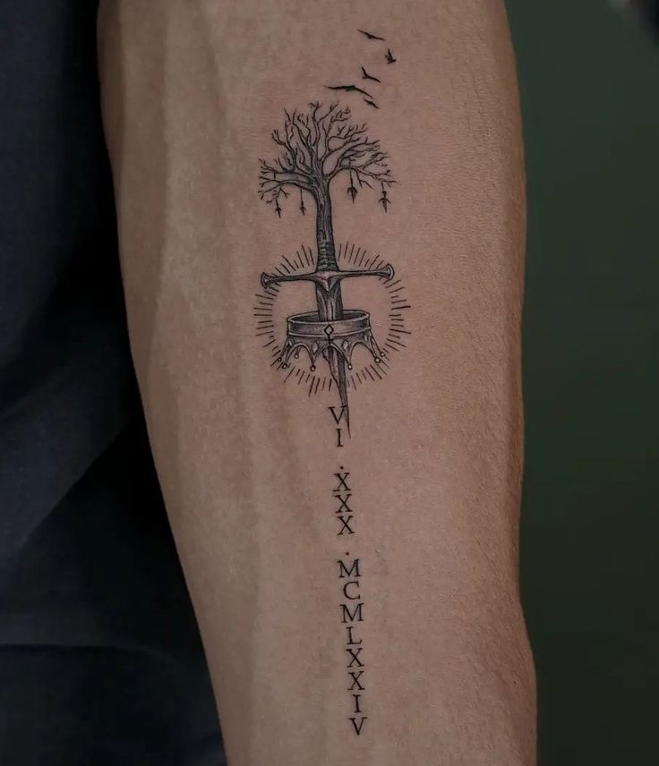 a person with a tattoo on their arm that has a cross and tree in it