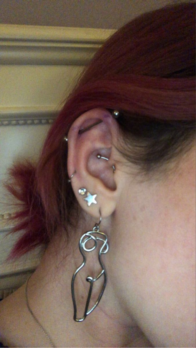 a woman with red hair wearing ear piercings