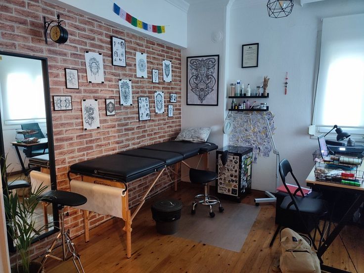 a room with a brick wall and lots of pictures on the wall, including a bench