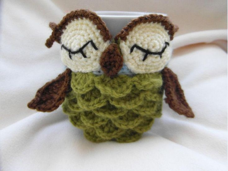 two crocheted owls sitting on top of a cup