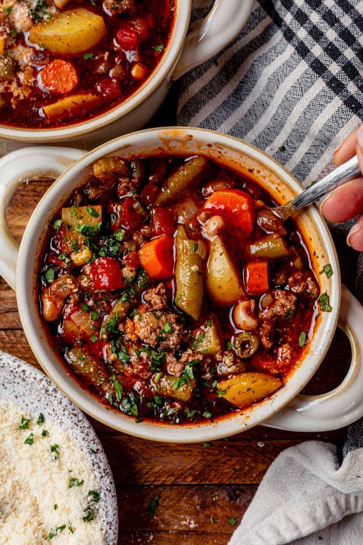 two bowls filled with stew on top of a wooden table