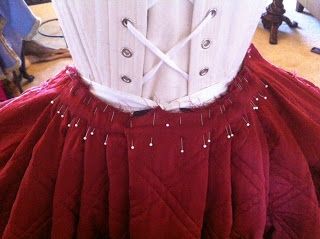 a red and white corset with pearls on it