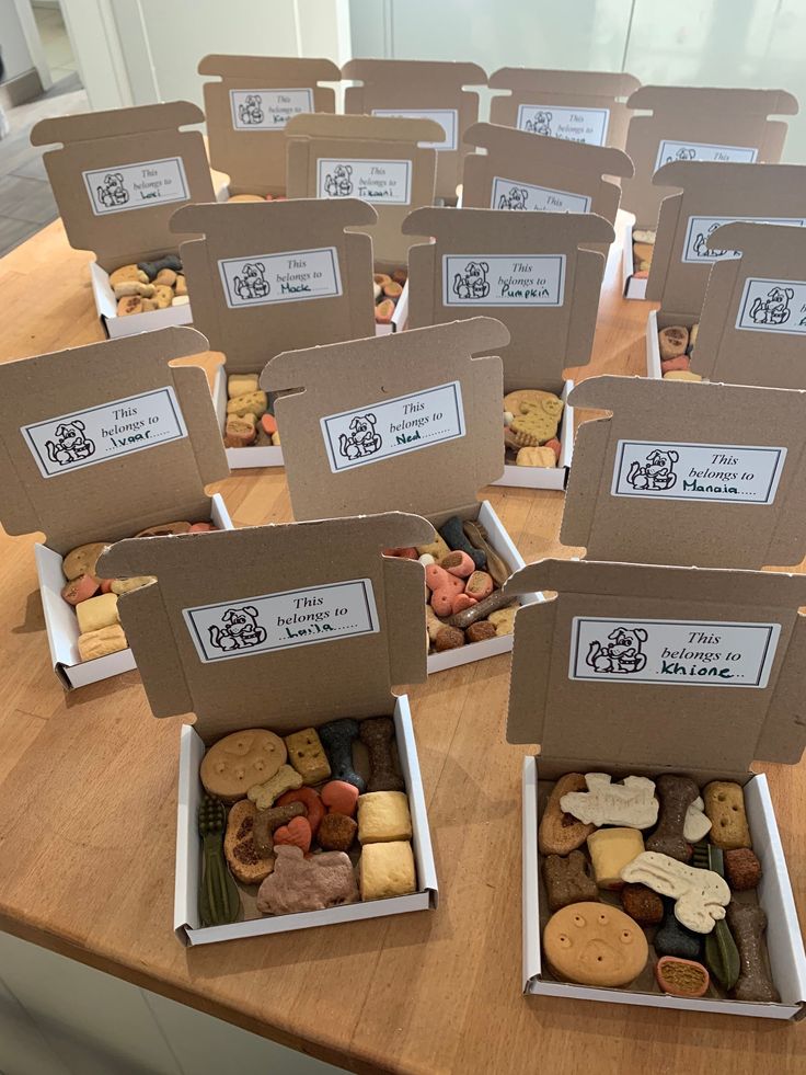 several boxes filled with different types of cookies on top of a wooden table next to each other