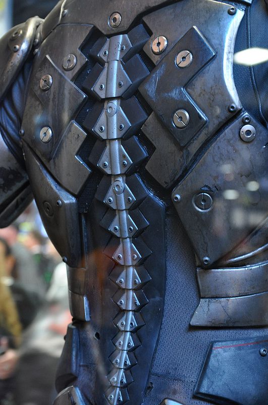 the back of a man's armor with spikes and rivets on it