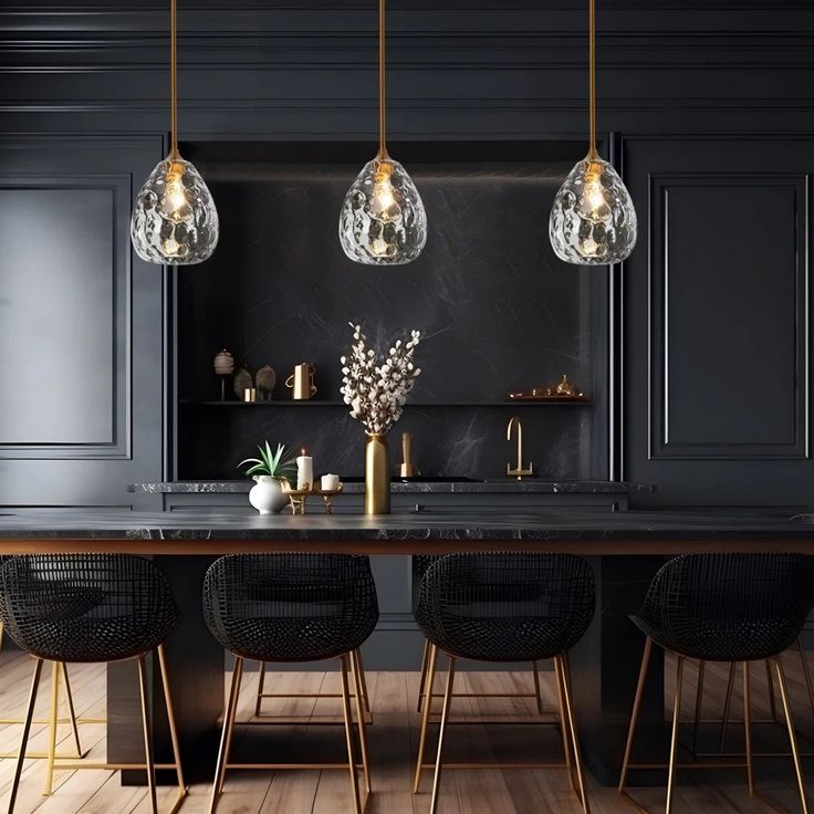 a kitchen with black walls and wooden floors, three pendant lights hanging over the island