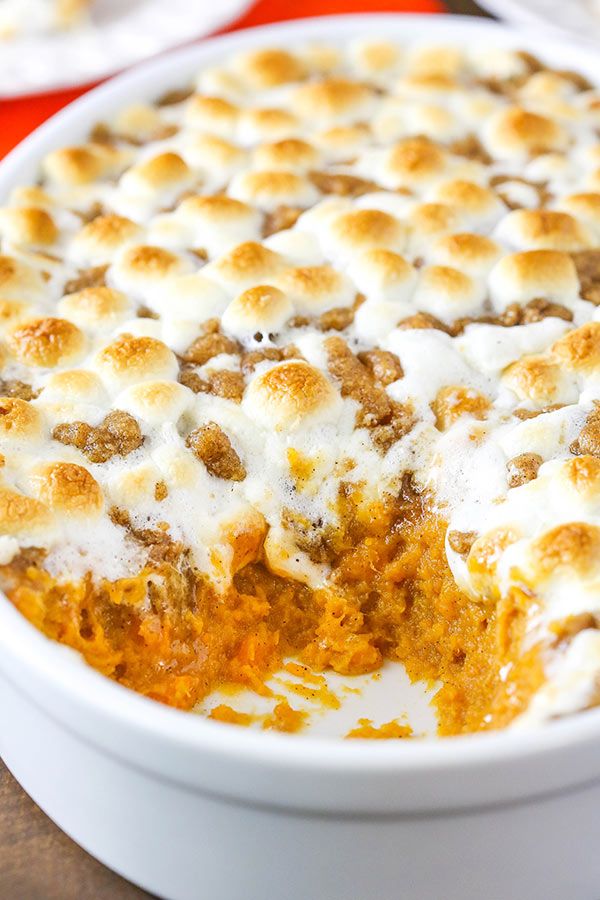 a casserole dish with marshmallows in it on a wooden table