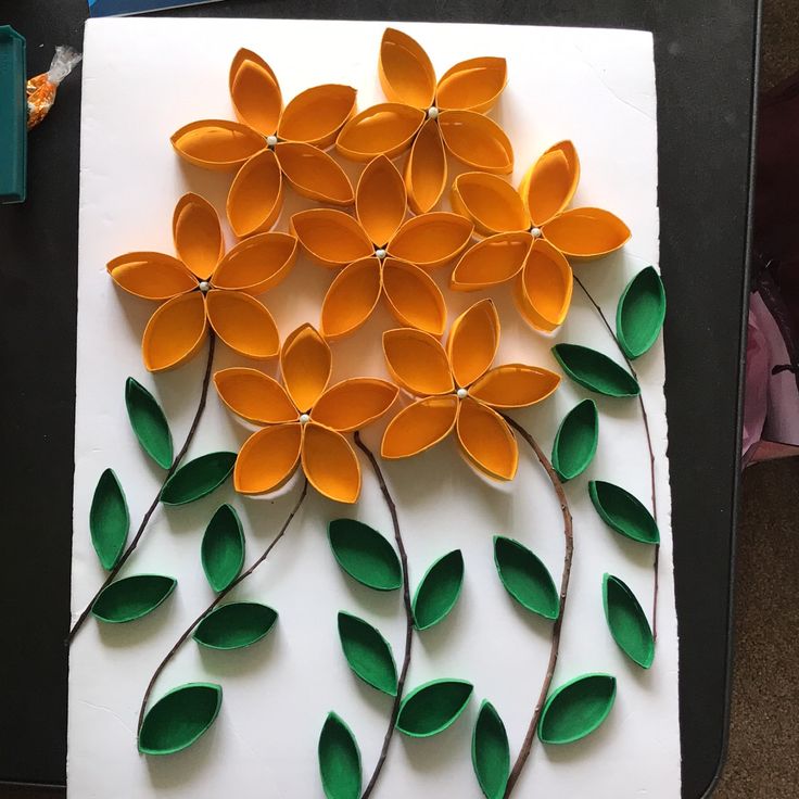 an art project made out of paper with orange flowers and green leaves