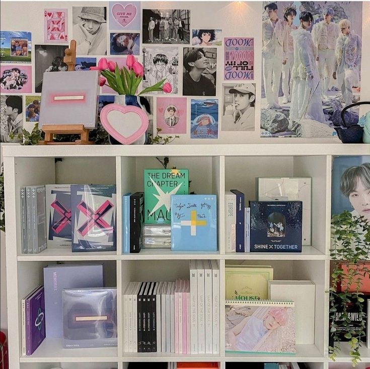 a book shelf filled with lots of books next to a wall covered in pictures and photos