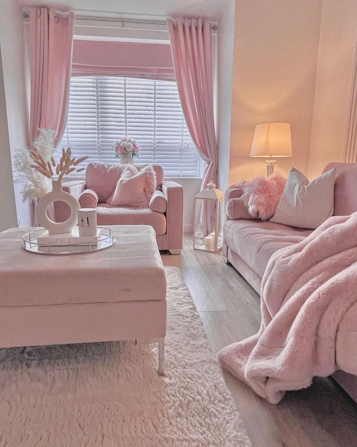 a living room filled with pink furniture and decor on top of a hard wood floor