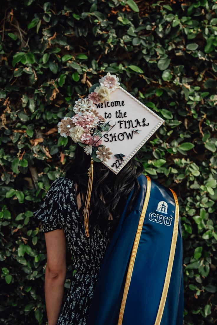 a woman wearing a graduation cap that says welcome to the total show on it's back