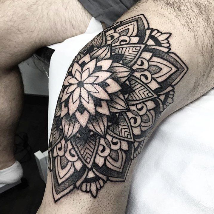 a man's arm with a black and white tattoo design on the left forearm