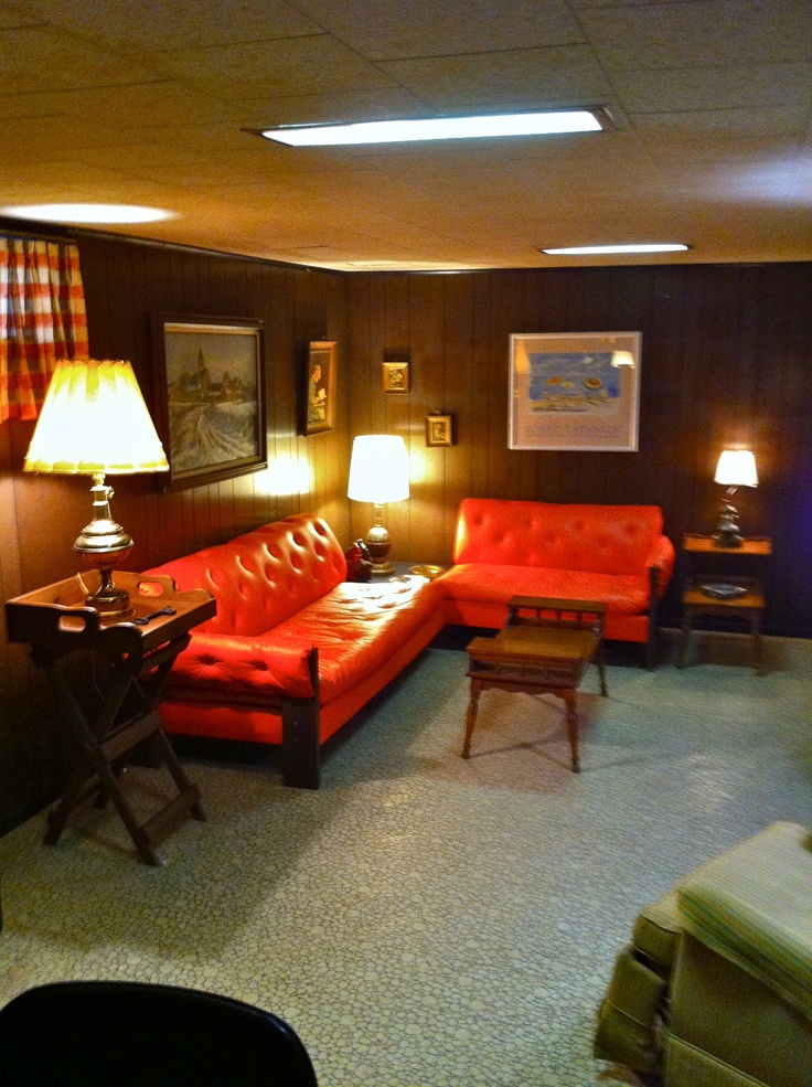 a living room with red couches and two lamps on either side of the couch