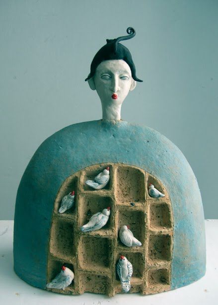 a ceramic sculpture of a woman with birds on her head