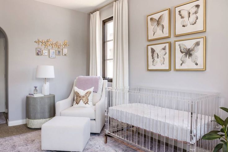 a baby's room with a crib, chair and pictures on the wall