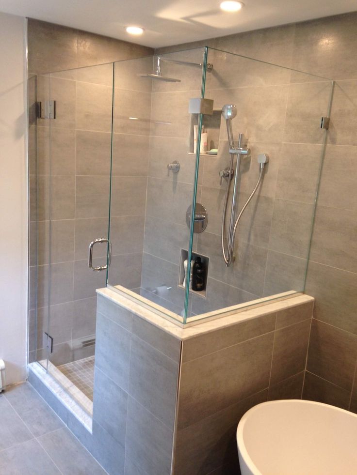 a bathroom with a walk in shower next to a white bathtub and toilet bowl