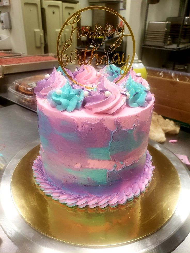 there is a pink and blue cake on the table