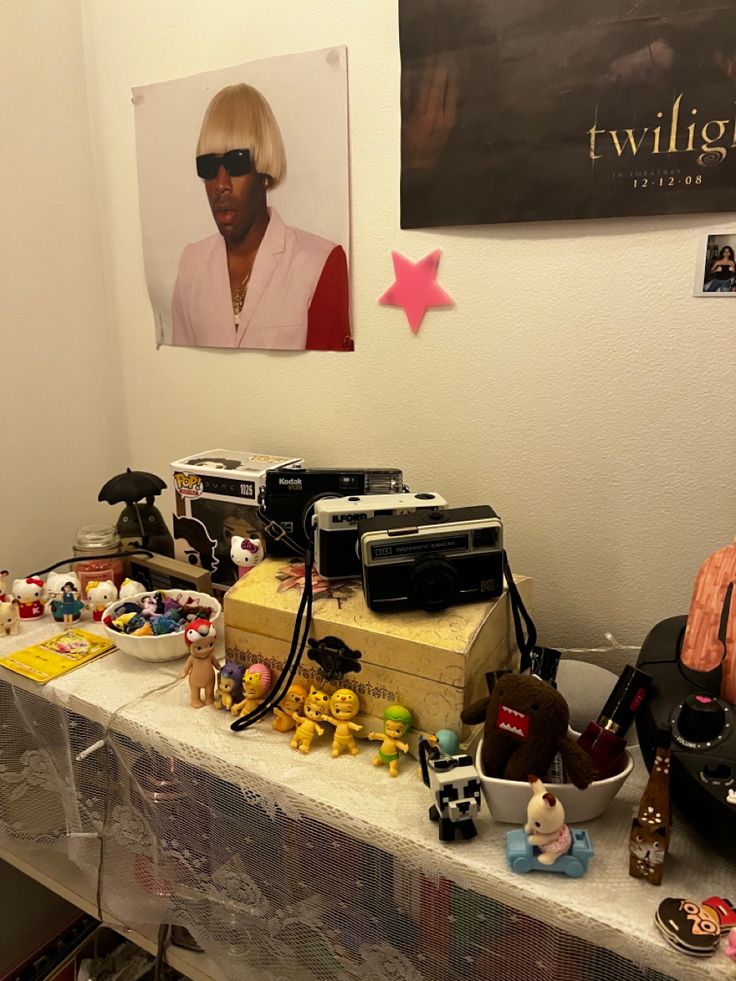 a table topped with lots of toys and other items next to a poster on the wall