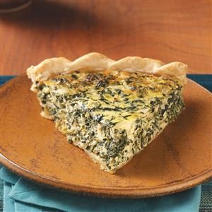 a slice of spinach quiche on a plate