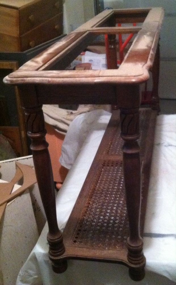 an old wooden table sitting on top of a bed