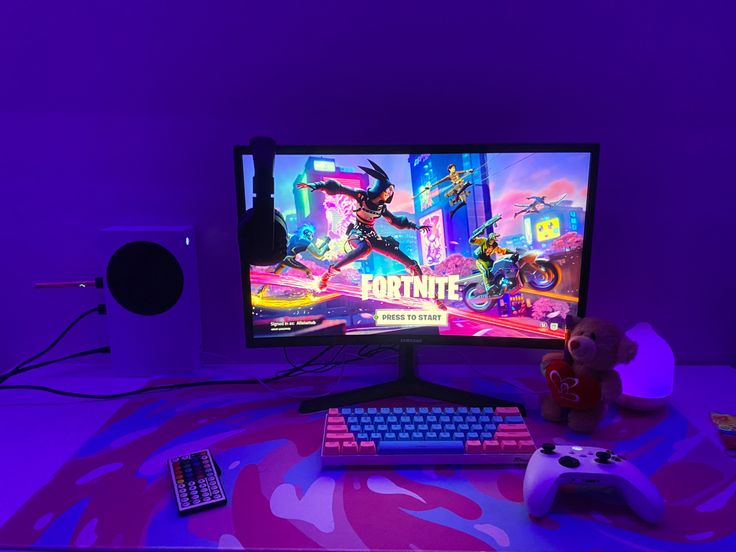 a desktop computer sitting on top of a desk next to a keyboard and monitor with the game fortnite logo on it