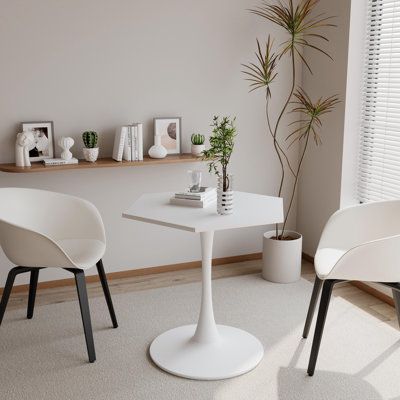 two white chairs and a table in a room