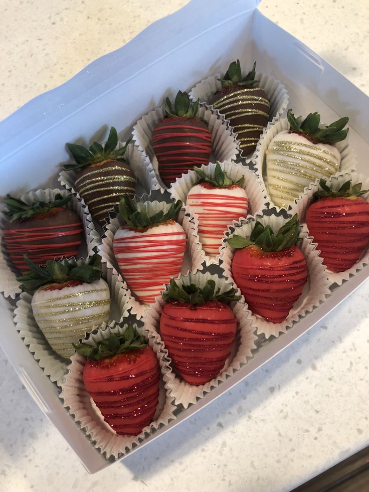 a box filled with chocolate covered strawberries on top of a counter