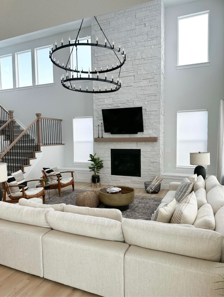 a living room filled with furniture and a flat screen tv mounted to the wall next to a fire place