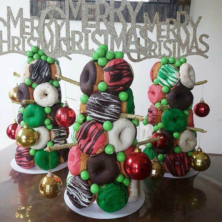 three decorated christmas trees sitting on top of a table