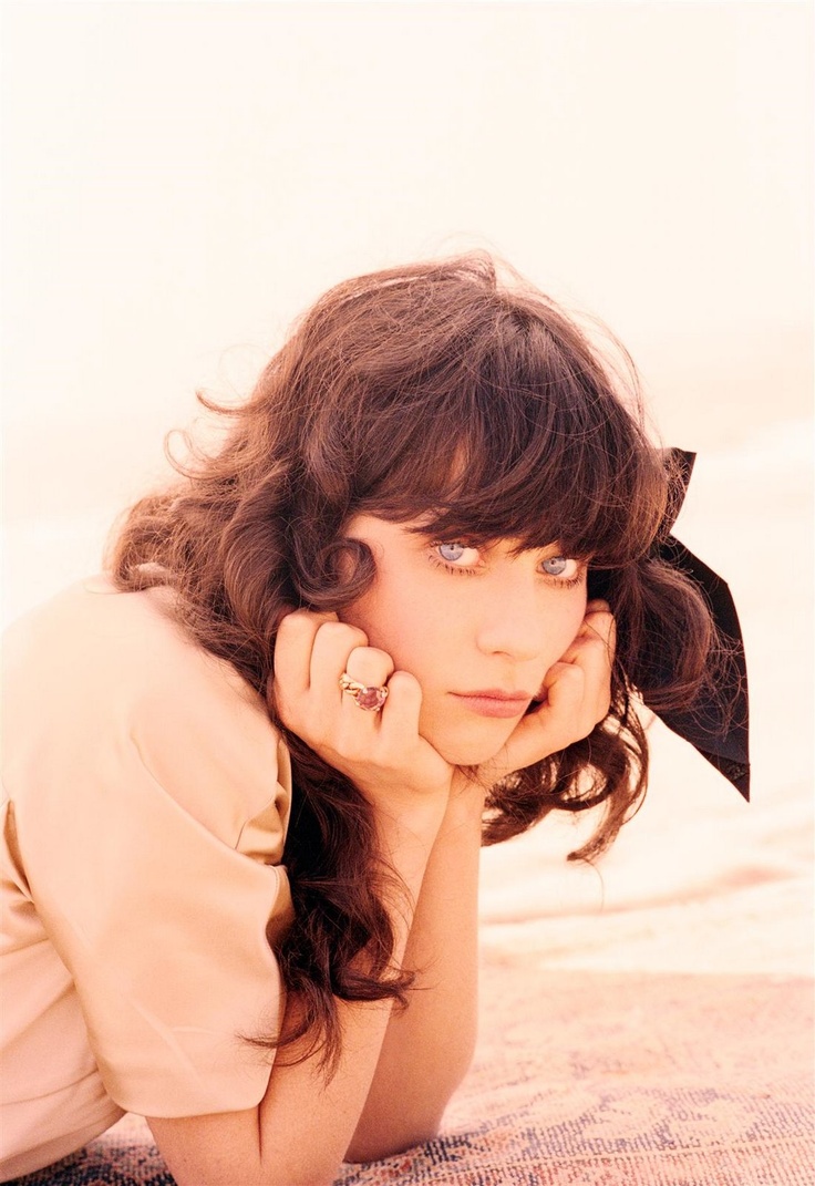 a woman laying on the ground with her hand under her chin