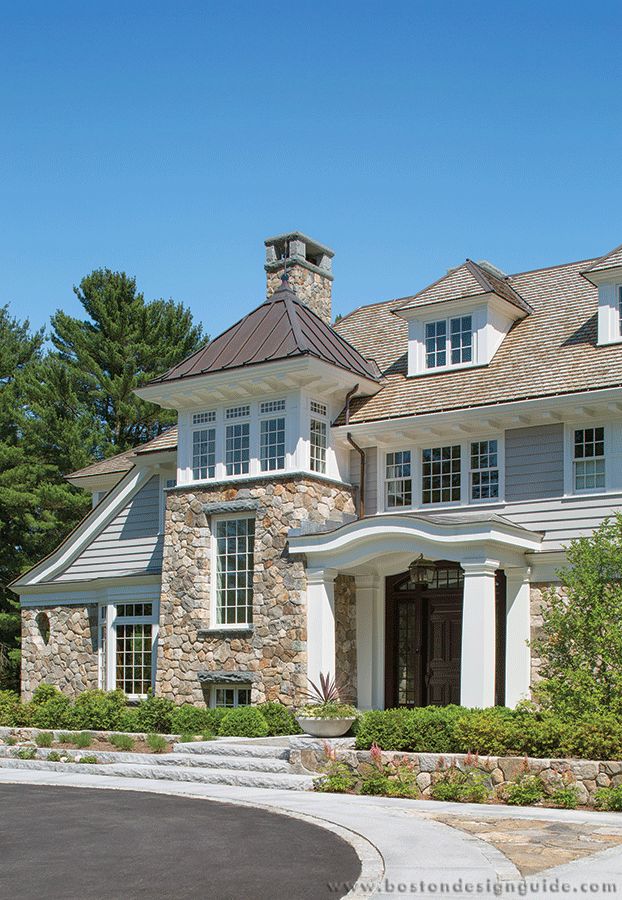 a large stone house with white trim and windows