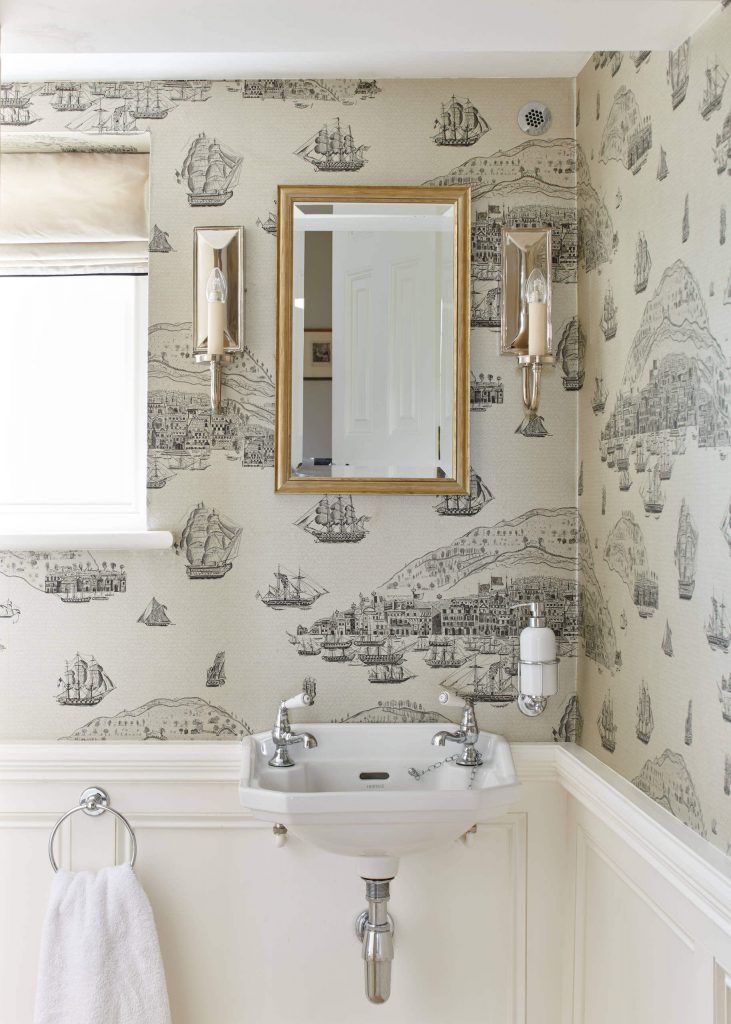 a white sink sitting under a bathroom mirror next to a wall mounted faucet