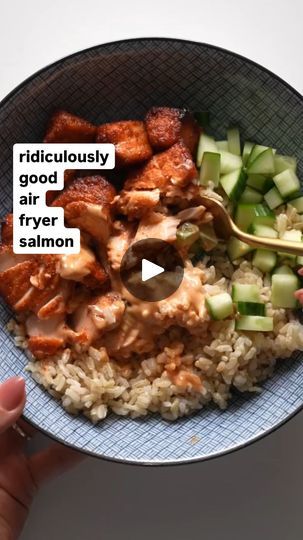 a bowl filled with rice, meat and cucumber slices on top of it