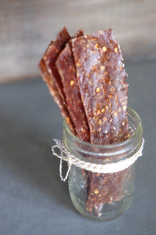 a jar filled with brown dog treats sitting on top of a table