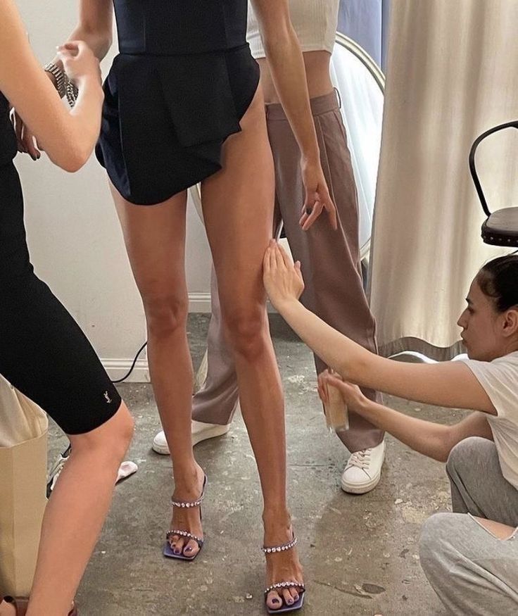 a group of people standing around each other in front of a woman's legs