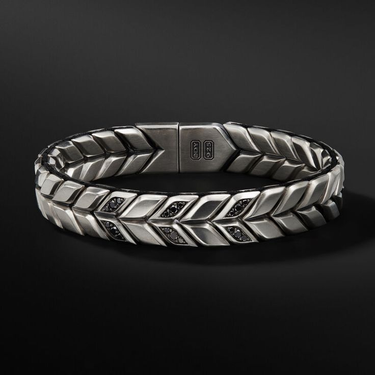 David Yurman skillfully reinterprets chevron—the ancient V-shaped pattern used in architecture and art—in this modern, sculptural collection. Viewed in relation to one another, each half of the motif is a mirror image of Cable. Sterling silverBlack nylonPavé black diamonds, 0.32 total carat weightBracelet, 12mmMagnetic clasp Mens Diamond Bracelet David Yurman, Chevron Patterns Bracelet, Bracelets Chevron, Petite Jewelry, David Yurman Mens, Chevron Bracelet, Men's Bracelets, Woven Bracelet, Woven Bracelets