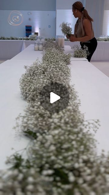 the woman is walking down the runway with flowers in front of her onlookers