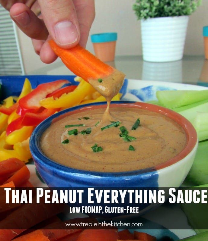 a person dipping some kind of sauce into a bowl with carrots and celery