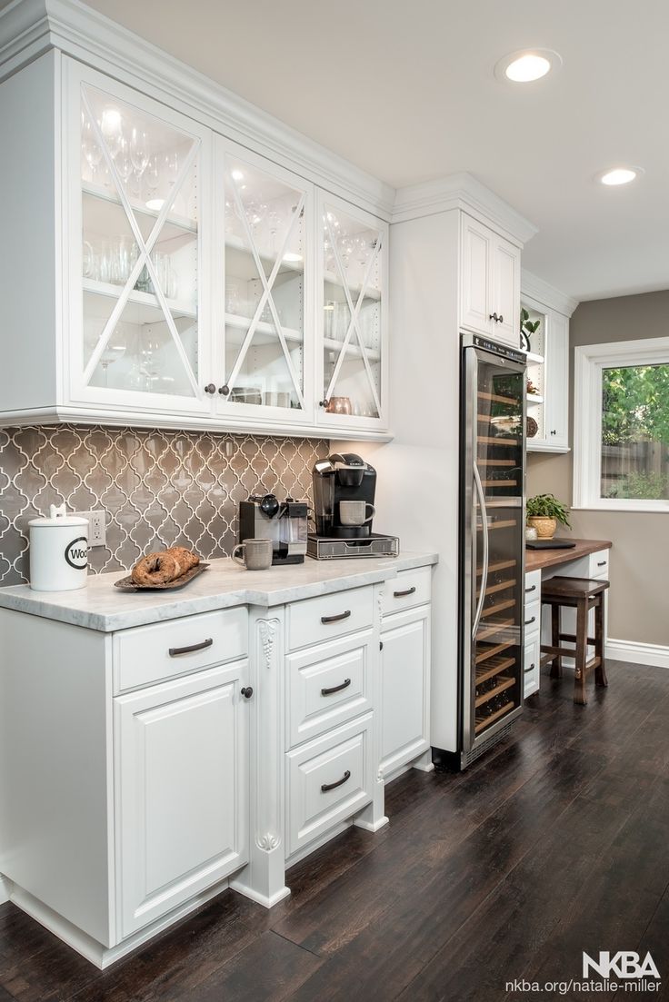 a kitchen with white cabinets and dark wood floors is pictured in this image from the inside