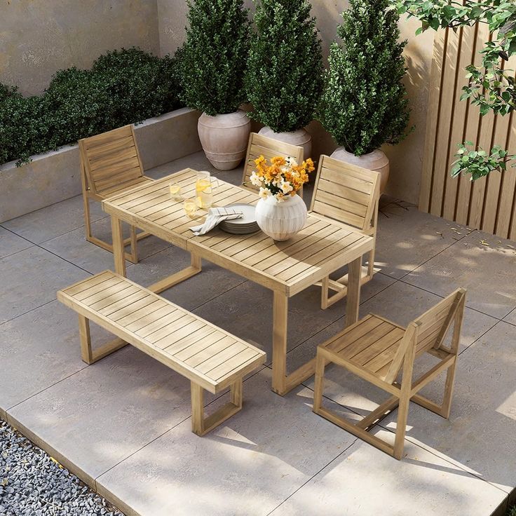 a wooden table and bench with flowers on it