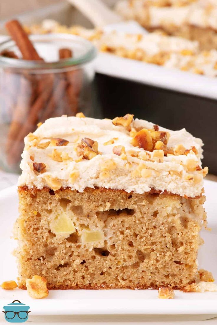 a close up of a slice of cake on a plate with cinnamon sticks in the background