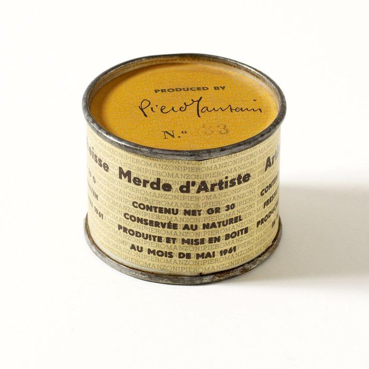 an old yellow tin can with writing on the bottom and inside, sitting on a white surface