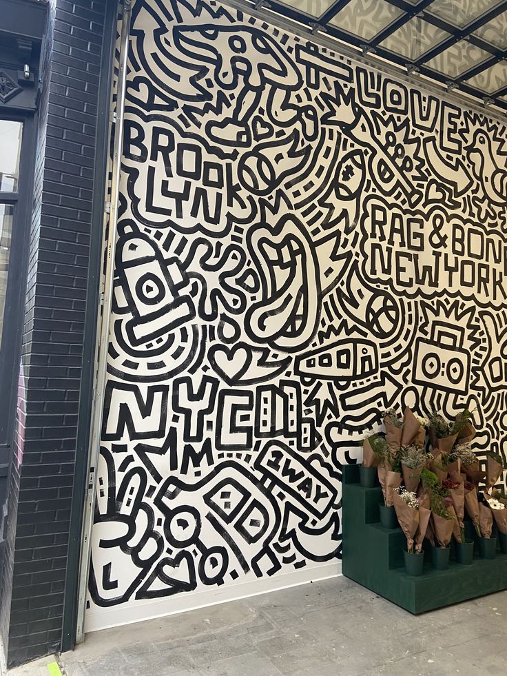 the wall is decorated with black and white designs on it's sides, along with two large vases filled with flowers