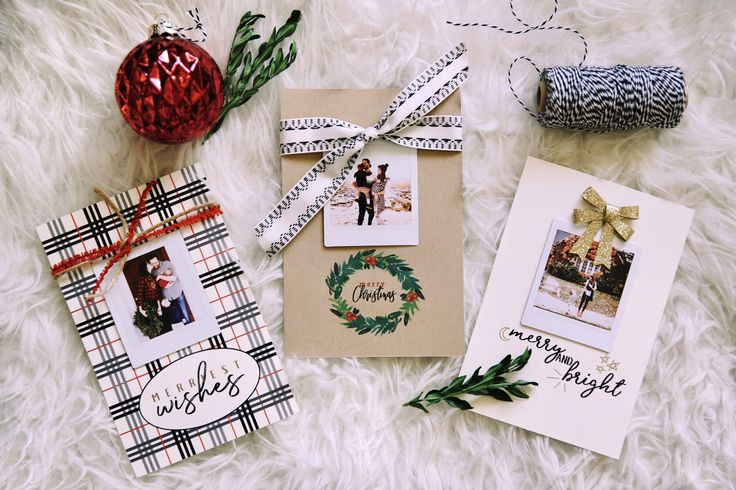 three christmas cards on a white furnishing next to a red ornament